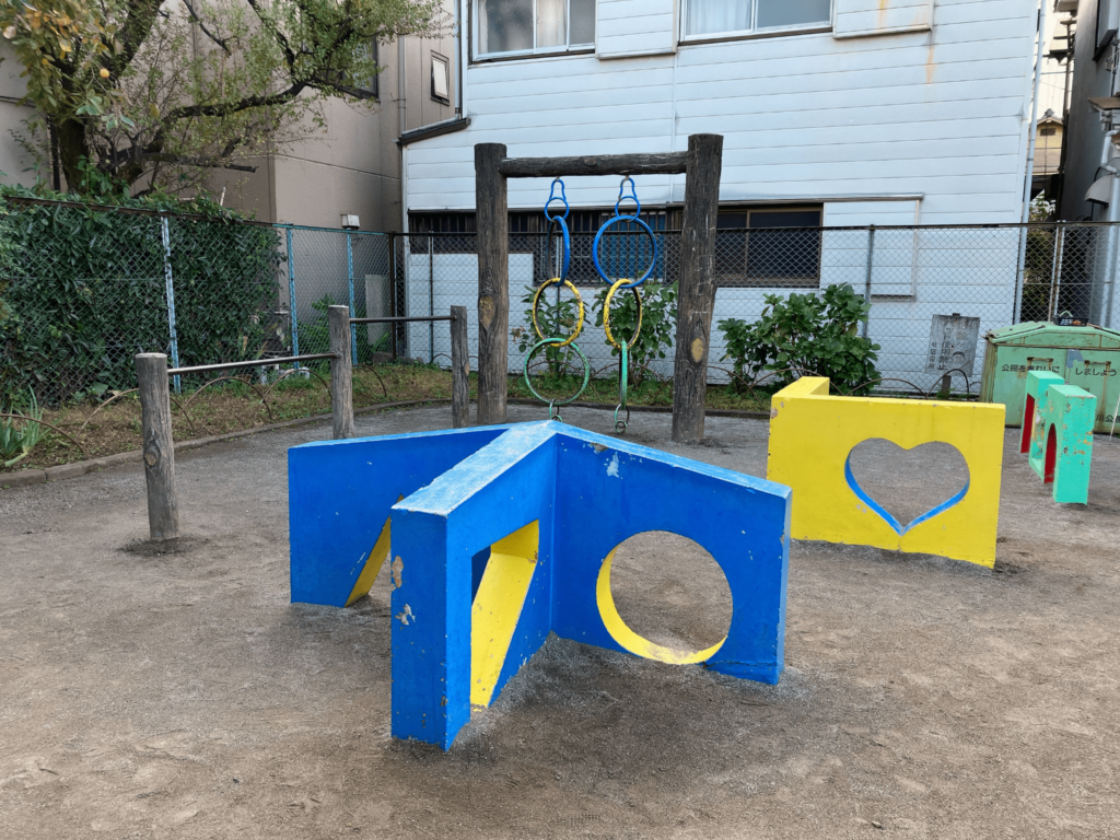 北区立西ヶ原三丁目児童遊園の様々な形の穴がある壁